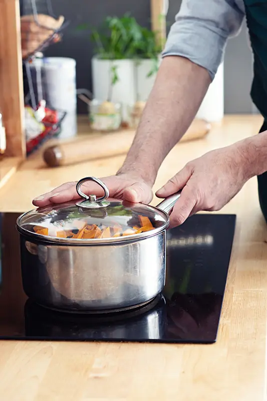 Cuisson de légumes en cocotte lors d’un atelier de cuisine alternative