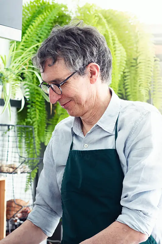 Portrait de Gilles Daveau en cuisine, tablier vert