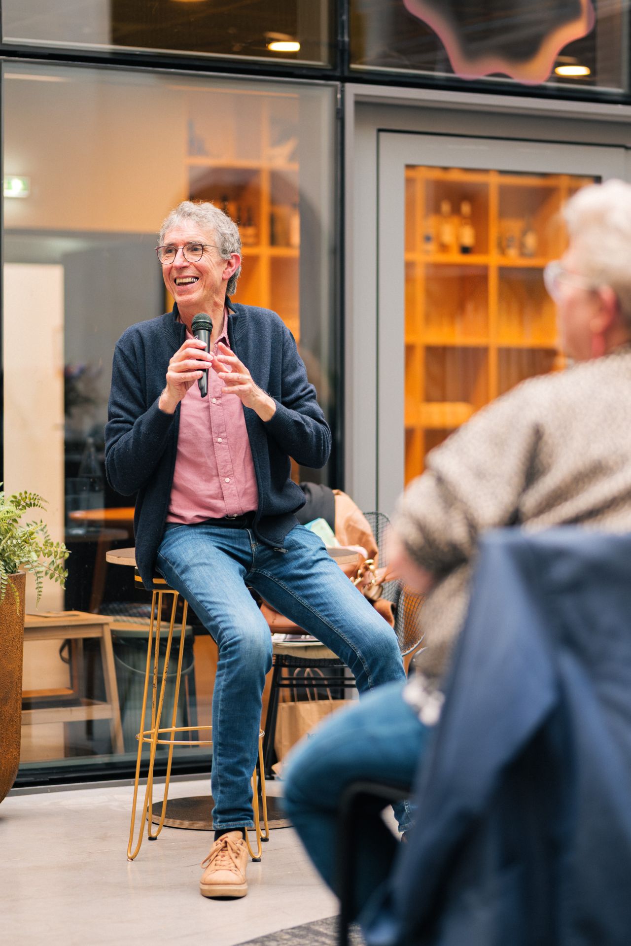 Gilles Daveau souriant, micro en main, devant son public
