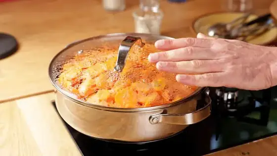 Geste de cuisson à couvert avec une casserole de légumes